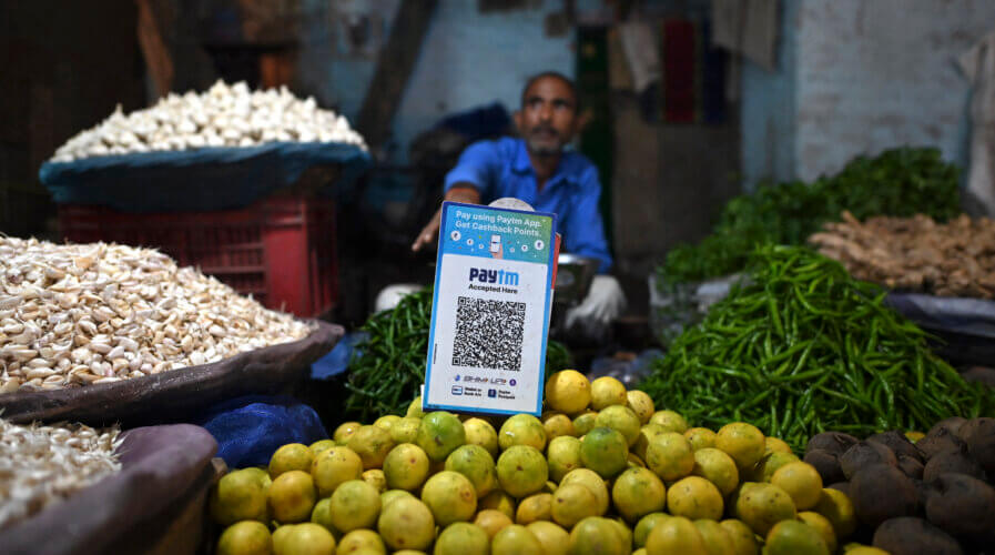 A vegetable vendor with a QR code of the Indian cellphone-based digital payment platform Paytm.